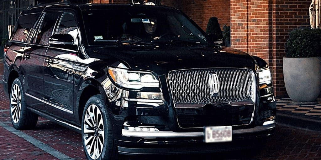 Luxury black SUV at upscale hotel entrance Boston limo service.